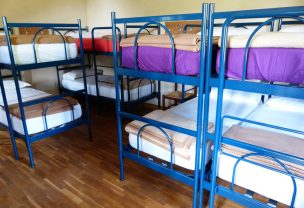 Several bunk beds with blue frames inside a hostel room
