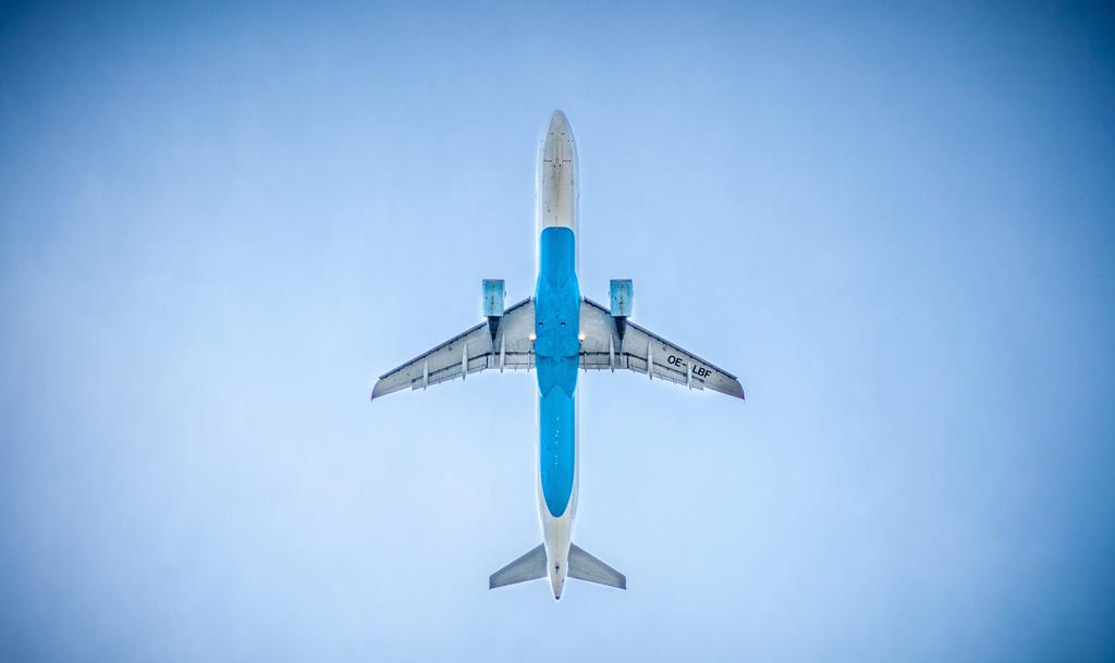 Image of passenger airplane taken from the ground looking at the bottom of it
