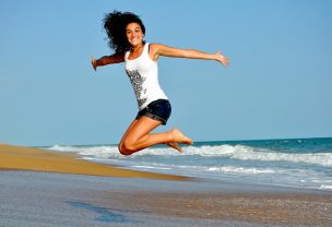 Woman jumping up into the air on a beach