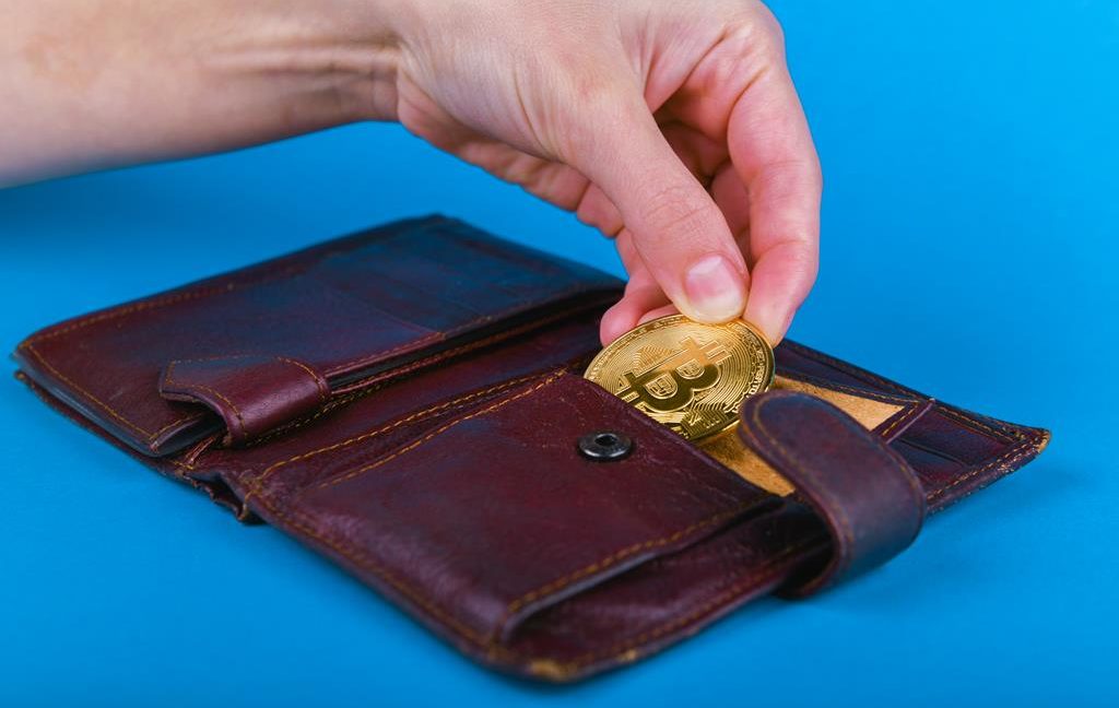 Inserting the coin into the leather wallet