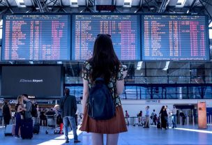 Image of a woman looking at departure board in an airport